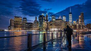 Night city skyline during blue hour with illuminated buildings, deep blue twilight sky, and balanced natural and artificial light